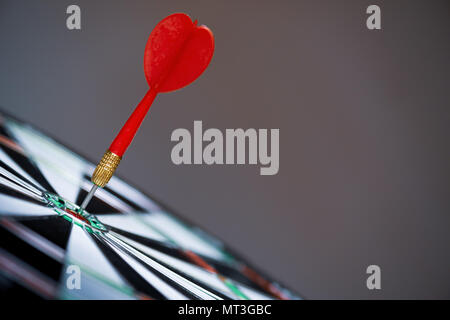 Close up shot red darts arrows in the target center on dark background. Business target or goal success and winner concept. Stock Photo