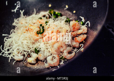 closeup photo of a prawn stir-fry being cooked in a wok Stock Photo