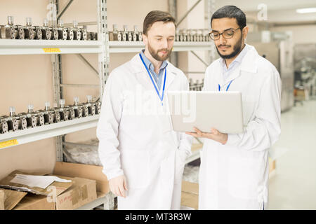 Serious colleagues of pressure sensors plant using laptop Stock Photo