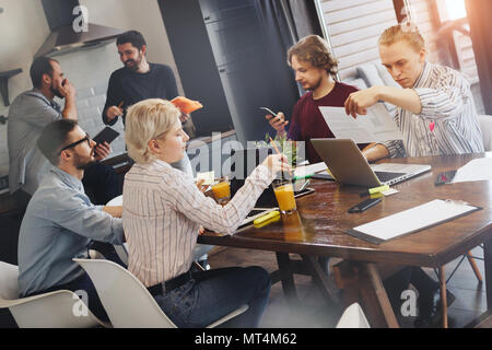 Group of creative students discussing and meeting in kitchen. Teamwork on new project startup Stock Photo