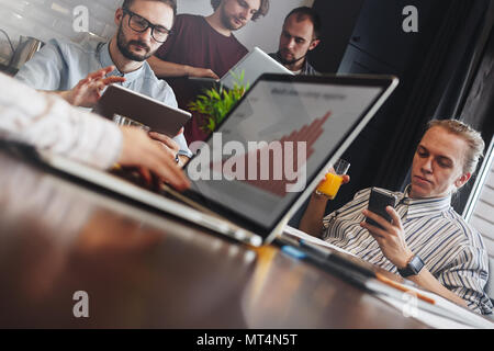 Team of financial analysts is discussing a plan to save company from bankruptcy. Business people meet in an open space office Stock Photo