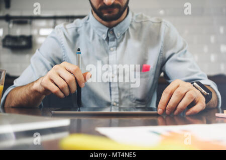 Bearded man using tablet for video conversation in modern office. Concept of young business people working at home. Bearded man use generic design lap Stock Photo