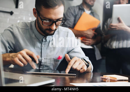 Coworking people meet and discuss a startup using a computer tablet and laptop. Teamwork. Business project. Young business people working together Stock Photo