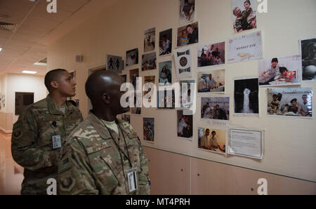 Chaplain (Capt.) John Appiah, 455th Air Expeditionary Wing, and Staff Sgt. Christopher Rodriguez, 455th AEW chaplain assistant, look at pictures of Afghan children in a hospital at Hamid Karzai International Airport, Kabul, Afghanistan, July 23, 2017. Religious support teams from Bagram Airfield visit six different locations in Afghanistan where a chaplain is not presently deployed. (U.S. Air Force photo by Staff Sgt. Benjamin Gonsier)