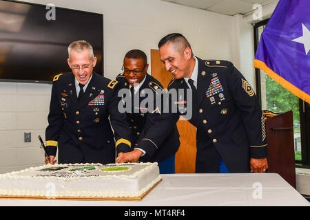 U.S. Army Maj. Gen. Paul K. Hurley, left, the chief of chaplains, Sgt. Maj. Ralph Martinez, right, the senior enlisted advisor of the Chaplain Corps, and a Soldier, who is youngest chaplain’s assistant in the National Capital Region, cut the ceremonial cake honoring the Chaplain Corps’ 242nd birthday at Joint Base Myer- Henderson Hall, in Arlington, Va., July 28, 2017.  (U.S. Army photo by Spc. Trevor Wiegel) Stock Photo