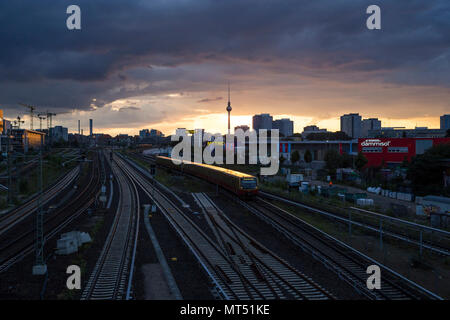 The sun sets over the TV Tower in Alexanderplatz. Seen from Warschauer Strasse, Berlin, Germany. Stock Photo