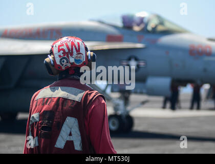 ARABIAN GULF (July 31, 2017) U.S. Navy Aviation Ordnanceman 2nd Class Zachary Watts, from Cedar Springs, Mich., observes flight operations aboard the aircraft carrier USS Nimitz (CVN 68), July 31, 2017, in the Arabian Gulf. Nimitz is deployed in the U.S. 5th Fleet area of operations in support of Operation Inherent Resolve. While in this region, the ship and strike group are conducting maritime security operations to reassure allies and partners, preserve freedom of navigation, and maintain the free flow of commerce. (U.S. Navy photo by Mass Communication Specialist 3rd Class Ian Kinkead) Stock Photo