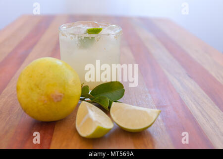 Key lime margarita garnished with fresh lime in a glass bar table Stock Photo