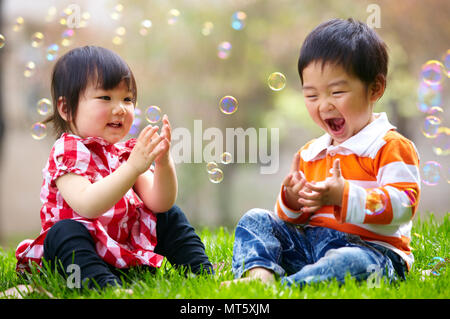 Two happy little asian kids playing outdoor in the sunny park Stock Photo -  Alamy