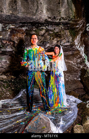 A Trash the Dress shoot in the Italian mountains by a small waterfall. First the couple went under the waterfall and then threw paint at each other. Stock Photo
