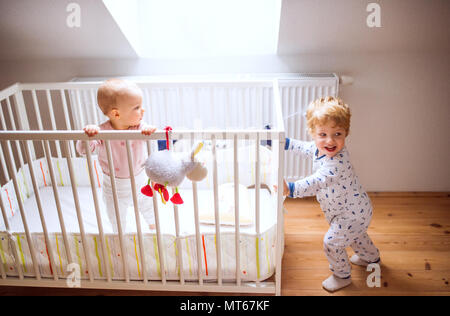 Two toddler children in bedroom at home. Stock Photo
