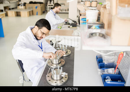 Technical assembler tightening bolts in workshop Stock Photo