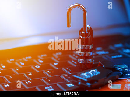 Online shopping concept with padlock open locked with cipher on laptop beside money cards. Non secure online shopping concept. Stock Photo