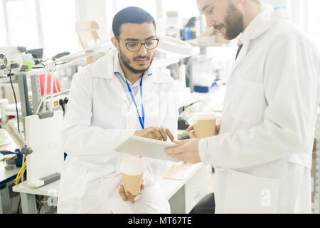 Serious engineers analyzing data on tablet Stock Photo