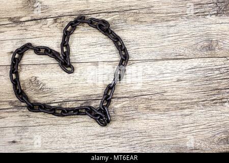 Rusty chain heart shape on wooden background Stock Photo