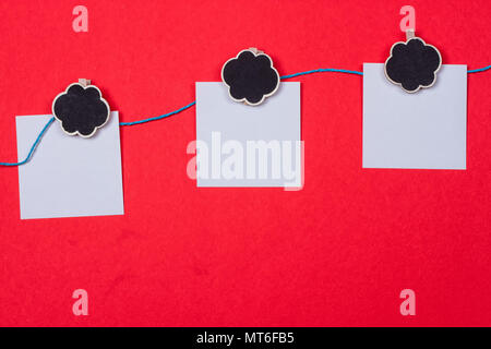 Clothespins, papers with a place for writing on a red background Stock Photo