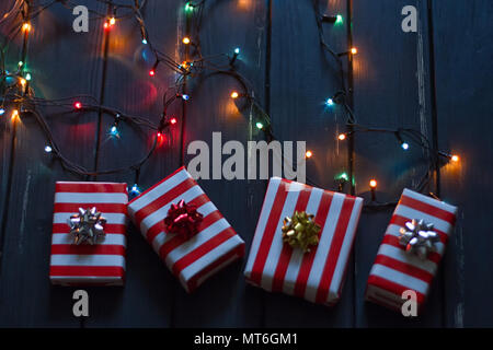 Gift box and garland lights over old wooden background Stock Photo