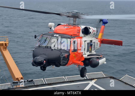 An Air Station Kodiak MH-60 Jayhawk helicopter prepares to land on the flight deck of the Coast Guard Cutter Healy in the Chukchi Sea off the coast of Alaska, July 28, 2017. For 150 years, the Coast Guard’s ability to protect American citizens and interests in Alaskan and Arctic waters has grown alongside Alaska’s ever-increasing role in global commerce, and Arctic exploration and national sovereignty. U.S. Coast Guard photo by Senior Chief Petty Officer Rachel Polish Stock Photo