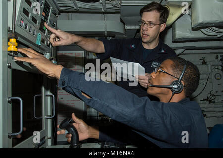 170726-N-DL434-027  CORAL SEA (July 26, 2017) Fire Controlman 2nd Class Michael Jordan (top), from Virginia Beach, Va., and Fire Controlman 2nd Class Franklin Martinez, from Philadelphia, prepare to fire the forward Close-In Weapons System aboard the amphibious assault ship USS Bonhomme Richard (LHD 6) during a live-fire exercise. Bonhomme Richard, flagship of the Bonhomme Richard Expeditionary Strike Group (ESG), is operating in the Indo-Asia-Pacific region to enhance partnerships and be a ready-response force for any type of contingency. (U.S. Navy photo by Mass Communication Specialist Seam Stock Photo