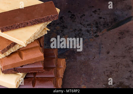 milk, dark and white chocolate bars on grunge background Stock Photo