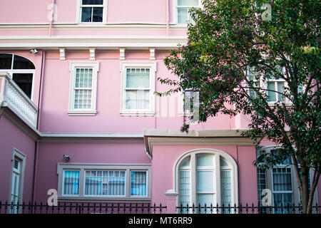 San Jose, Costa Rica. February 2, 2018. A pink colonial building with a fence in front of it in San Jose, Costa RIca Stock Photo