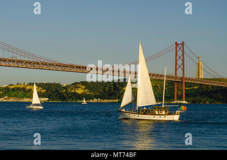 LISBON, PORTUGAL - MAY 16, 2018. sailboat sailing near a bridge in Lisbon, Portugal Stock Photo