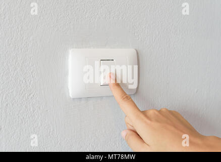 Close up of woman finger  turning on light switch with white background copy space. Stock Photo