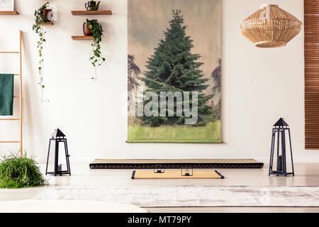 Tree poster on the wall, lamps, plants, tatami mat and mattress in a Japanese room interior Stock Photo