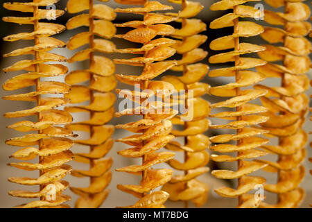 Fried potato chips on wooden sticks closeup Stock Photo