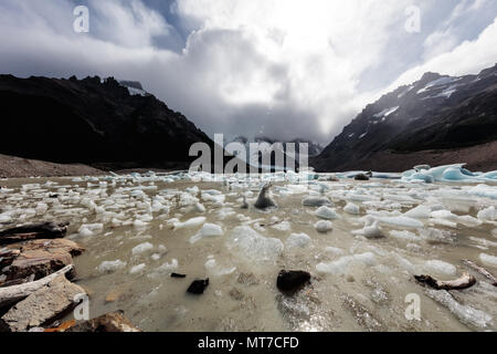 Small blocks of ice dot the shore of a glacial lake at Fitzroy in Argentina Stock Photo