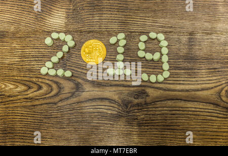 cryptocurrency coin and candies 2019 financial report year text on wood. Stock Photo