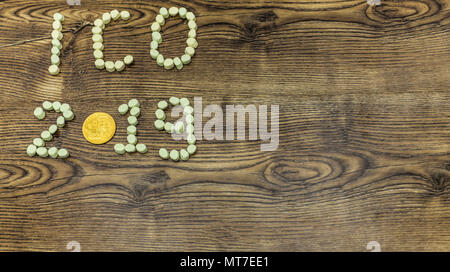 ICO 2019 text and cryptocurrency coin on wooden background. Stock Photo