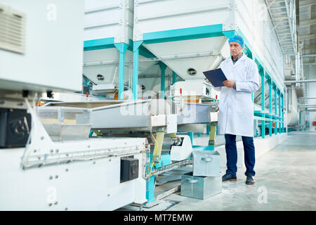 Senior Man Working in Modern Factory Stock Photo