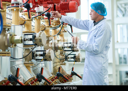 Worker Checking Pipes in Modern Factory Stock Photo