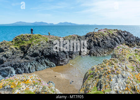 UK, Anglesey, Newborough. 19th May 2018. A couple of fishermen catch fish from the rocks at Llanddwyn Island. Stock Photo