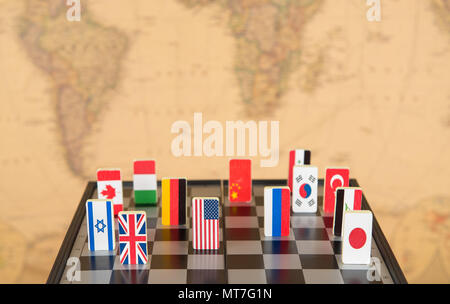 symbols of countries on the chessboard against against the background the political map of the world. Conceptual photo, political games. Stock Photo