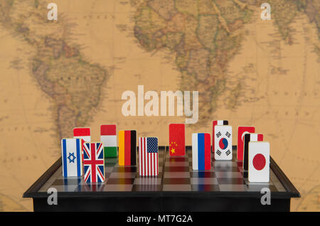 symbols of countries on the chessboard against against the background the political map of the world. Conceptual photo, political games. Stock Photo