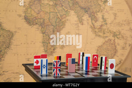 symbols of countries on the chessboard against against the background the political map of the world. Conceptual photo, political games. Stock Photo