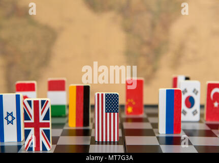 symbols of countries on the chessboard against against the background the political map of the world. Conceptual photo, political games. Stock Photo