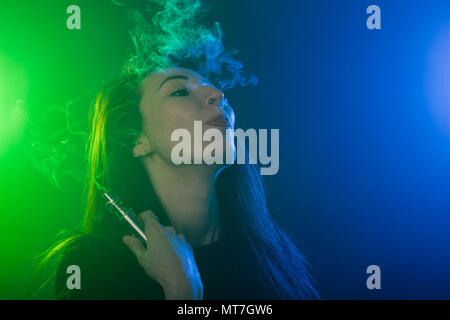 young woman smoking electronic cigarette Stock Photo