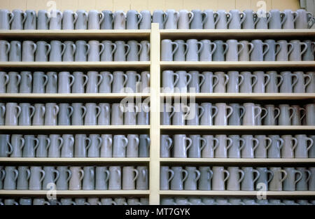 Wooden shelves hold row upon row of plain pottery beer steins ready to serve thirsty celebrants during the historic Oktoberfest, an annual festival since 1810 that now draws more than six million beer lovers to Munich in Bavaria, Germany. For more than two weeks, Oktoberfest beer flows into 1-liter stoneware or glass mugs under dozens of party tents sponsored by six Munich breweries. Total beer consumption has reached as much as 7.5-million liters (1,981,000 U.S. gallons) during the famed folk festival. Stock Photo