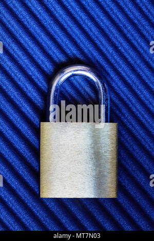 Golden padlock on blue ridged background with copy space. Concept of security, safety and protection. Stock Photo