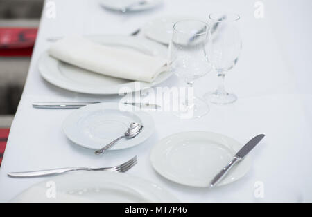 White empty plates and glasses served on a table for a celebration Stock Photo