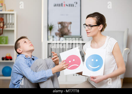 Professional psychologist working with autistic boy in her office Stock Photo