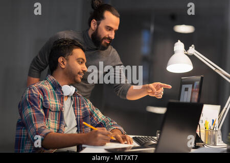 creative team with computer working late at office Stock Photo