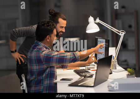 creative team with computer working late at office Stock Photo