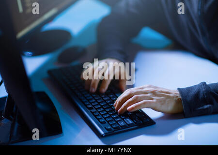 hacker hands typing on computer keyboard Stock Photo