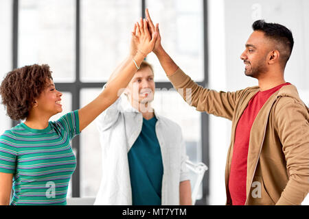 happy creative team making high five at office Stock Photo