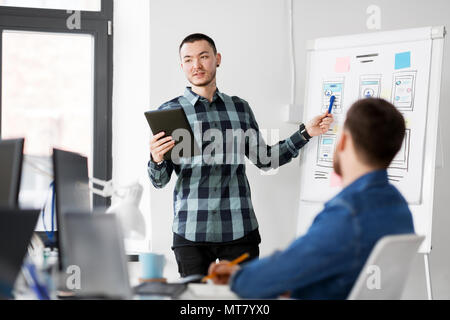 man showing tablet pc to creative team at office Stock Photo