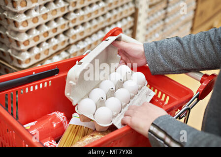 Hands woman with packages of white eggs in the store Stock Photo